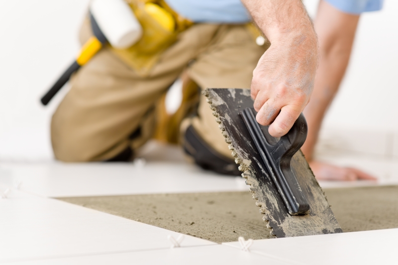 1633794-home-improvement-renovation-handyman-laying-tile
